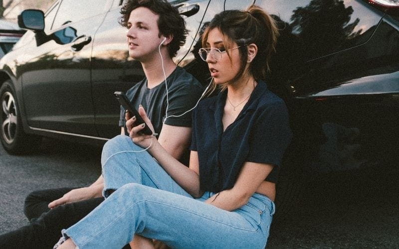 boy and girl listening with earphones 