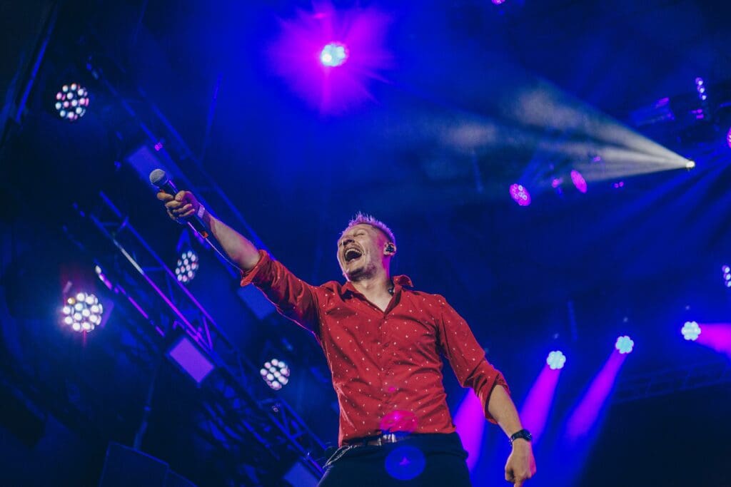 Man performing on stage holding a microphone