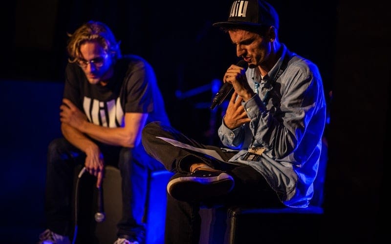 Two men with microphones on stage