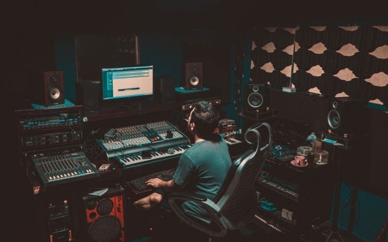 man at mixing desk in soundproofed studio