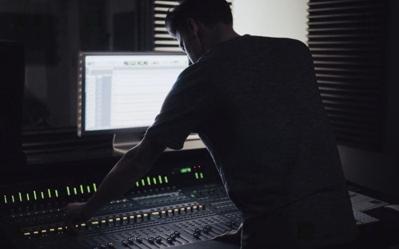 man at mixing desk in soundproof studio