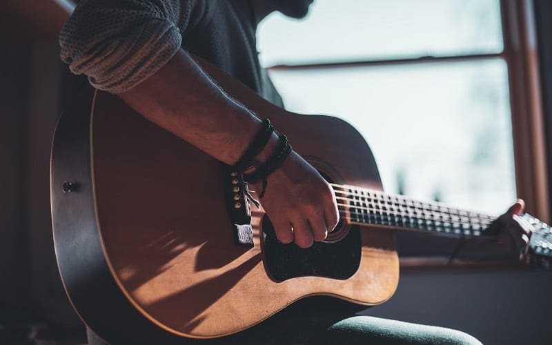 man playing acoustic guitar