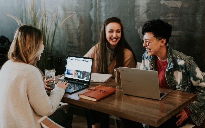 Women with laptops collaborating on music branding